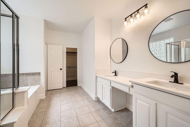 9812 Whitley Bay Dr, Austin, TX 78717 - bathroom with double vanity, tile patterned floors, a stall shower, a garden tub, and a walk in closet