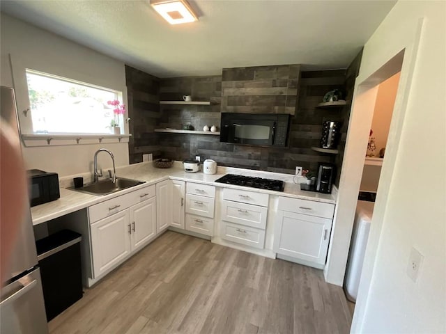 14902 Nuttall Dr, Austin, TX 78724 - kitchen featuring open shelves, a sink, black appliances, and white cabinetry