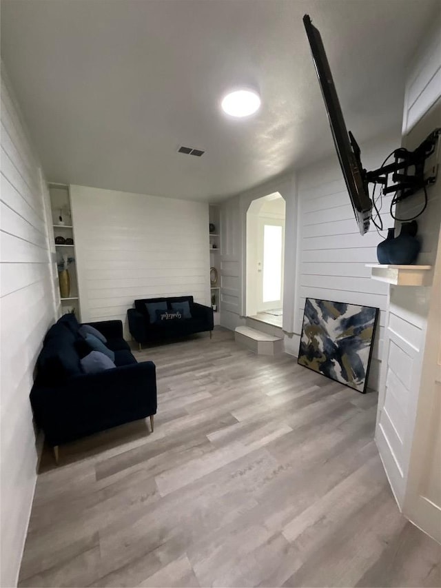 14902 Nuttall Dr, Austin, TX 78724 - living area with arched walkways, wood walls, wood finished floors, and a glass covered fireplace