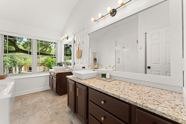 11542 Gun Fight Ln, Austin, TX 78748 - full bathroom with vaulted ceiling, vanity, a shower stall, a bath, and baseboards