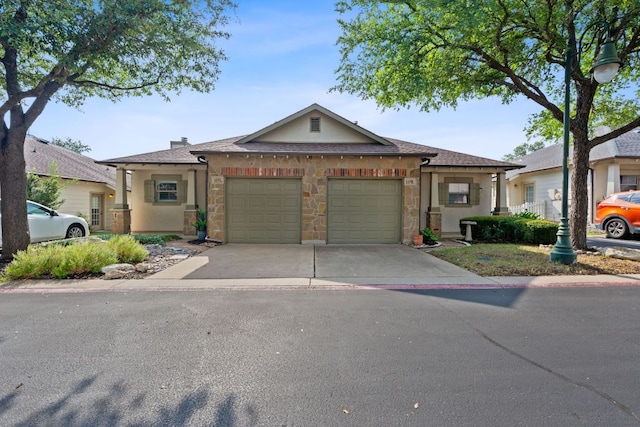 6801 Beckett Rd Unit 119L, Austin, TX 78749 - view of front of property with an attached garage, driveway, stucco siding, and stone siding