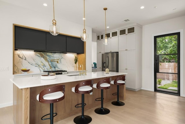 517 Tillery St Unit 3, Austin, TX 78702 - kitchen featuring stainless steel refrigerator with ice dispenser, a sink, tasteful backsplash, baseboards, and light wood-style flooring