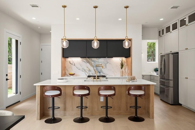 517 Tillery St Unit 3, Austin, TX 78702 - kitchen with stainless steel fridge, decorative backsplash, healthy amount of natural light, light countertops, and recessed lighting