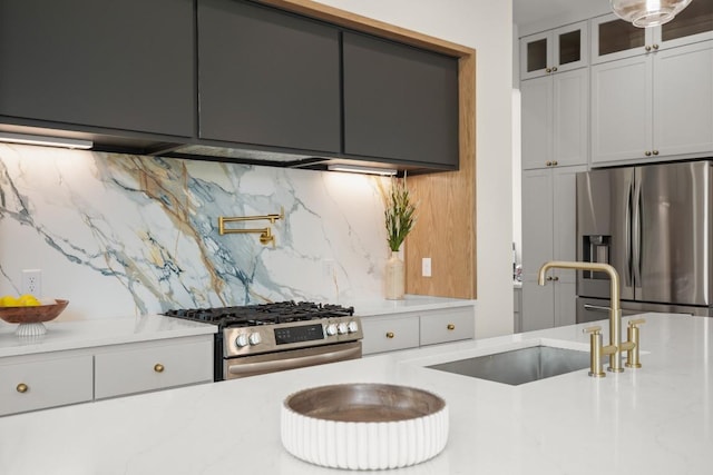 517 Tillery St Unit 3, Austin, TX 78702 - kitchen featuring stainless steel appliances, a sink, glass insert cabinets, tasteful backsplash, and white cabinetry