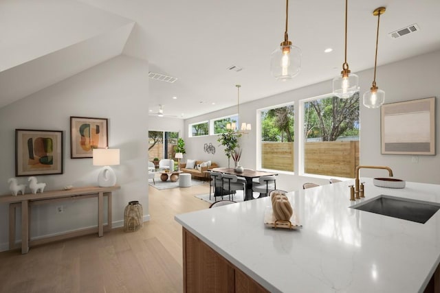517 Tillery St Unit 3, Austin, TX 78702 - kitchen with a sink, light wood-type flooring, recessed lighting, light stone countertops, and decorative light fixtures