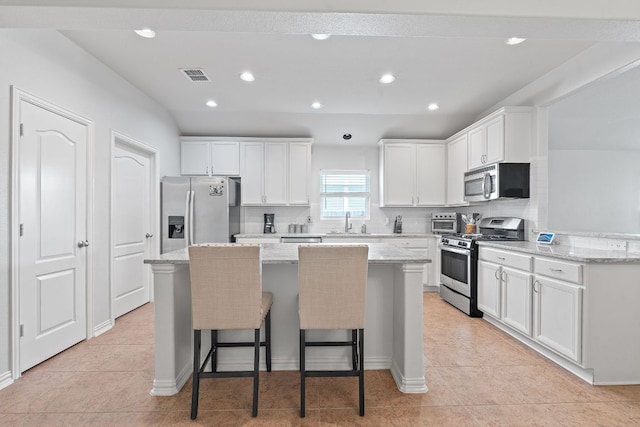 3712 Brean Down Rd, Pflugerville, TX 78660 - kitchen featuring appliances with stainless steel finishes, a kitchen island, a sink, white cabinets, and recessed lighting