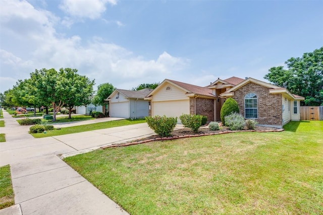 205 Tolcarne Dr, Hutto, TX 78634 - ranch-style home with brick siding, driveway, a front lawn, and an attached garage