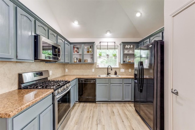 205 Tolcarne Dr, Hutto, TX 78634 - kitchen featuring black appliances, a sink, vaulted ceiling, open shelves, and light wood-type flooring