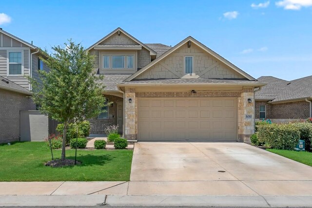 6010 Principale Dr, Pflugerville, TX 78660 - view of front of property featuring driveway, a front lawn, roof with shingles, stone siding, and a garage
