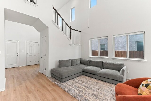 6010 Principale Dr, Pflugerville, TX 78660 - living area with light wood-style floors, a towering ceiling, baseboards, and stairs