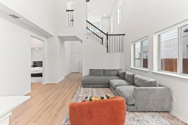 6010 Principale Dr, Pflugerville, TX 78660 - living area featuring wood finished floors, a high ceiling, stairway, and baseboards
