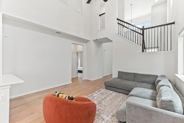 6010 Principale Dr, Pflugerville, TX 78660 - living area with wood finished floors, a ceiling fan, a high ceiling, baseboards, and a chandelier