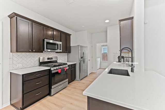 6010 Principale Dr, Pflugerville, TX 78660 - kitchen with stainless steel appliances, a sink, dark brown cabinetry, decorative backsplash, and recessed lighting