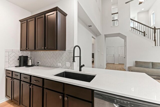 6010 Principale Dr, Pflugerville, TX 78660 - kitchen with dishwasher, a sink, dark brown cabinets, tasteful backsplash, and light countertops