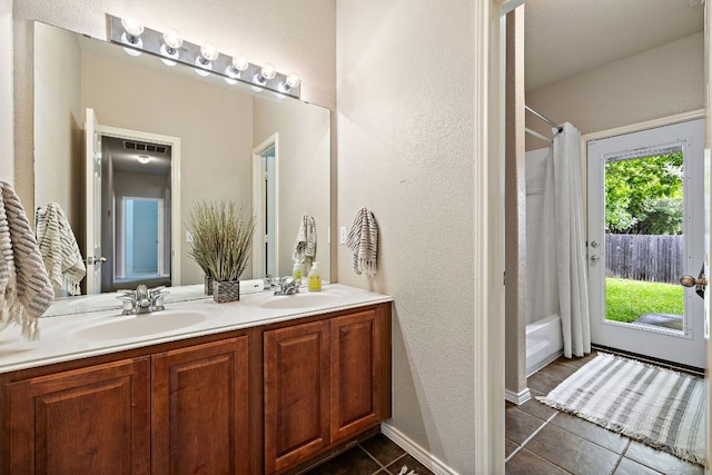 1518 Foppiano Loop, Round Rock, TX 78665 - bathroom featuring double vanity, tile patterned floors, a textured wall, and shower / bath combination with curtain
