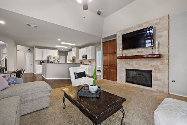 1518 Foppiano Loop, Round Rock, TX 78665 - living area with arched walkways, a ceiling fan, a fireplace, dark carpet, and recessed lighting