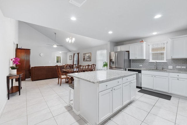 2211 Bettylou Ln, Austin, TX 78754 - kitchen featuring stainless steel appliances, a sink, a ceiling fan, a kitchen island, and white cabinets