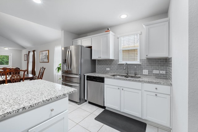 2211 Bettylou Ln, Austin, TX 78754 - kitchen featuring appliances with stainless steel finishes, a sink, white cabinets, tasteful backsplash, and light stone countertops