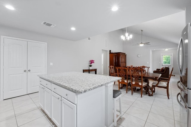 2211 Bettylou Ln, Austin, TX 78754 - kitchen with light tile patterned floors, freestanding refrigerator, a ceiling fan, a center island, and white cabinetry