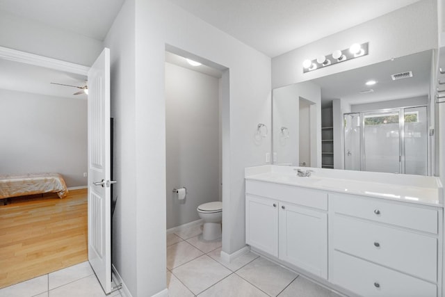 2211 Bettylou Ln, Austin, TX 78754 - ensuite bathroom featuring toilet, vanity, a shower stall, tile patterned floors, and a ceiling fan