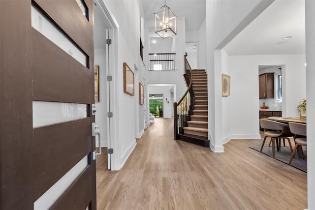1329 Da Vinci Trl, Leander, TX 78641 - entrance foyer with light wood finished floors, stairway, a chandelier, and a towering ceiling