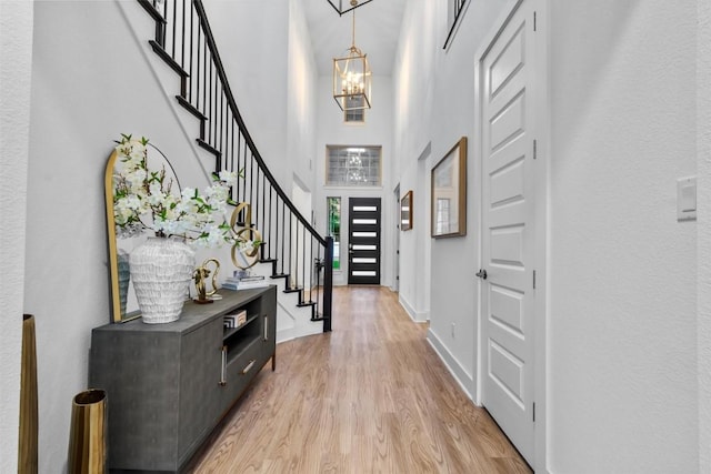 1329 Da Vinci Trl, Leander, TX 78641 - entrance foyer with a chandelier, stairway, light wood finished floors, and a high ceiling