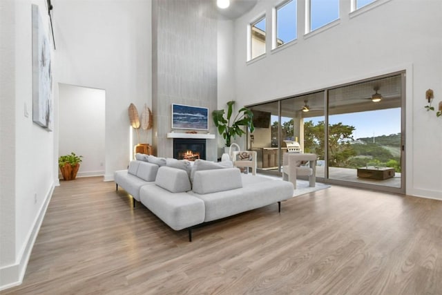 1329 Da Vinci Trl, Leander, TX 78641 - living room featuring a towering ceiling, a large fireplace, wood finished floors, and plenty of natural light