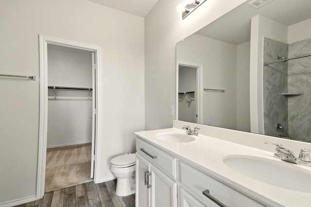 112 Black Alder St, Georgetown, TX 78626 - full bath featuring a walk in closet, double vanity, wood finished floors, toilet, and tiled shower