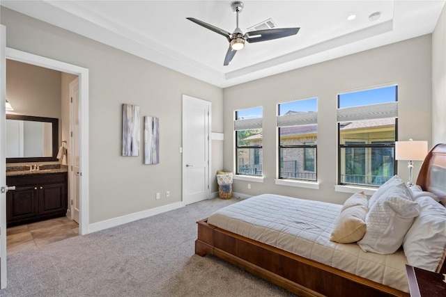 1017 Sue Ann Rose Dr, Austin, TX 78717 - bedroom featuring light colored carpet, a raised ceiling, connected bathroom, and a ceiling fan