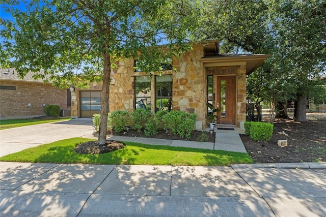 1017 Sue Ann Rose Dr, Austin, TX 78717 - view of front facade with stone siding, concrete driveway, and an attached garage