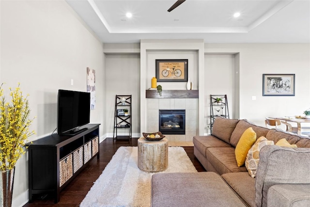 1017 Sue Ann Rose Dr, Austin, TX 78717 - living area with dark wood finished floors, a fireplace, a tray ceiling, baseboards, and a ceiling fan
