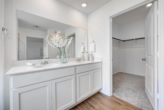 3109 Windy Vane Dr, Pflugerville, TX 78660 - full bathroom with double vanity, a spacious closet, wood finished floors, and baseboards