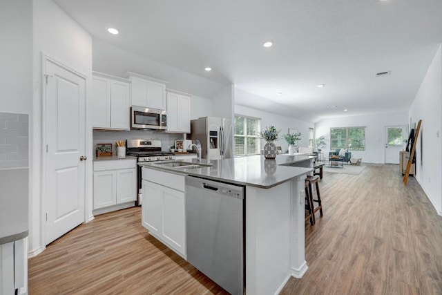 3109 Windy Vane Dr, Pflugerville, TX 78660 - kitchen featuring stainless steel appliances, plenty of natural light, a kitchen island with sink, light wood-type flooring, and recessed lighting