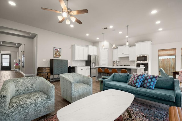 18621 James Power Ct, Austin, TX 78738 - living room featuring wood finished floors, ceiling fan, recessed lighting, baseboards, and attic access