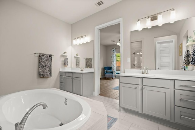 18621 James Power Ct, Austin, TX 78738 - ensuite bathroom with two vanities, a tub with jets, and a ceiling fan