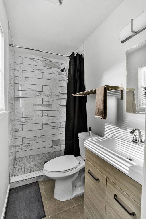 1205 Arthur Stiles Rd, Austin, TX 78721 - full bath with toilet, vanity, tiled shower, and tile patterned floors