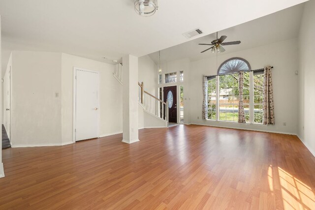 12303 Shropshire Blvd, Austin, TX 78753 - unfurnished living room with stairway, plenty of natural light, and light wood-style floors