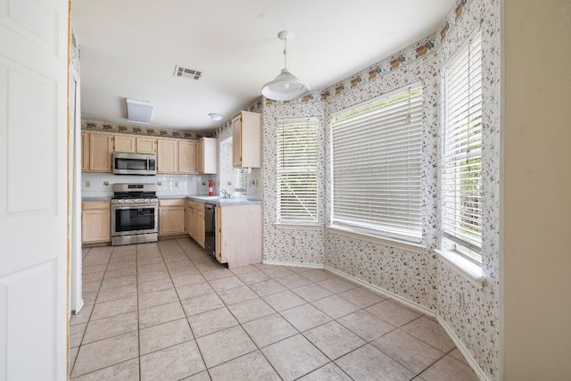 12303 Shropshire Blvd, Austin, TX 78753 - kitchen with appliances with stainless steel finishes, wallpapered walls, light brown cabinets, light countertops, and baseboards