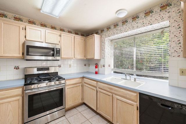 12303 Shropshire Blvd, Austin, TX 78753 - kitchen with appliances with stainless steel finishes, light brown cabinetry, a sink, wallpapered walls, and light countertops