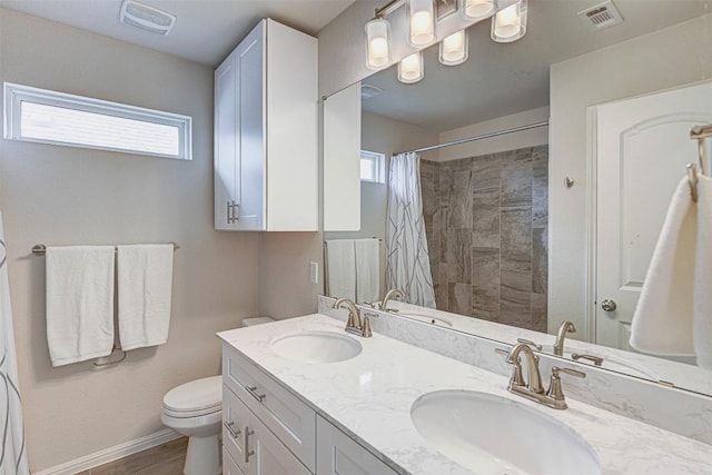 20517 Kangal Ct, Pflugerville, TX 78660 - bathroom with double vanity, toilet, tiled shower, and baseboards