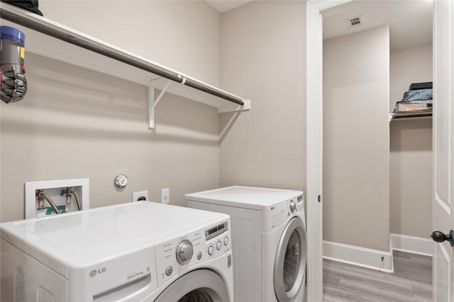 5400 Alonso Dr, Austin, TX 78738 - laundry room featuring washer and clothes dryer, light wood-style flooring, and baseboards