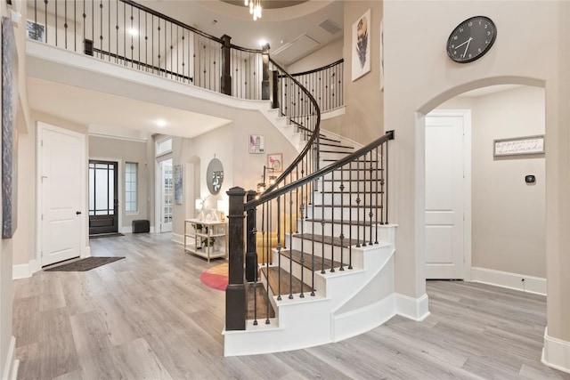5400 Alonso Dr, Austin, TX 78738 - foyer with arched walkways, wood finished floors, baseboards, stairway, and a towering ceiling