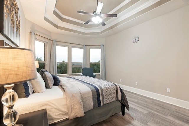 5400 Alonso Dr, Austin, TX 78738 - bedroom featuring ornamental molding, multiple windows, wood finished floors, baseboards, and a tray ceiling