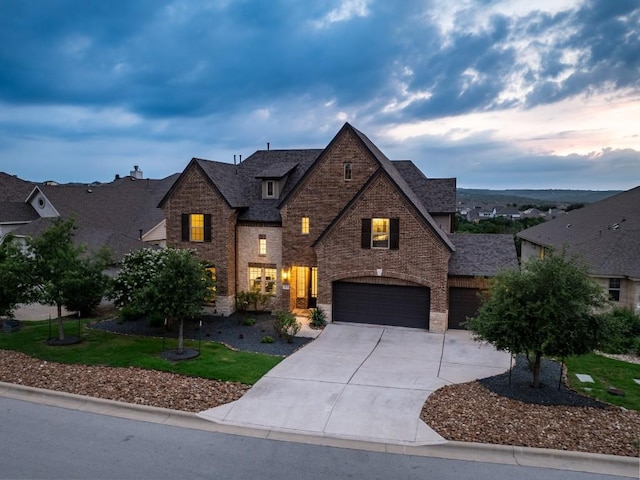 5400 Alonso Dr, Austin, TX 78738 - view of front facade with brick siding, concrete driveway, an attached garage, and roof with shingles