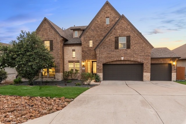 5400 Alonso Dr, Austin, TX 78738 - view of front of property with brick siding, driveway, roof with shingles, and an attached garage