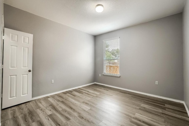 9008 Tall Sky Trce, Austin, TX 78724 - empty room with wood finished floors, baseboards, and a textured ceiling
