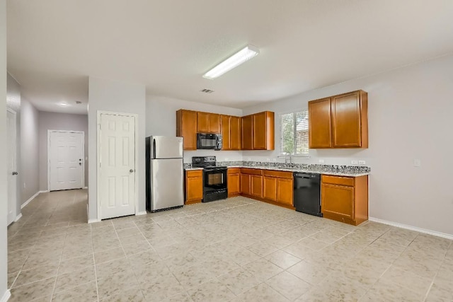 9008 Tall Sky Trce, Austin, TX 78724 - kitchen with black appliances, light countertops, brown cabinets, and baseboards