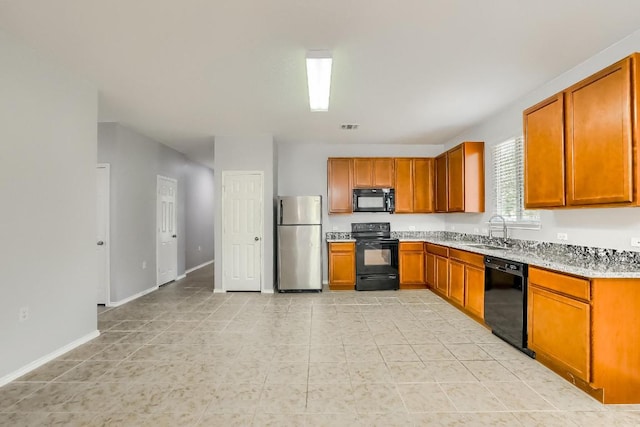 9008 Tall Sky Trce, Austin, TX 78724 - kitchen with black appliances, a sink, brown cabinetry, and light tile patterned floors