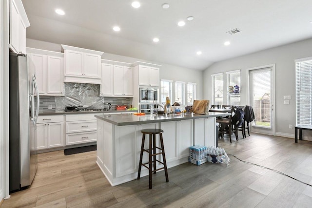 13212 Carol Lawler Ln, Manor, TX 78653 - kitchen with appliances with stainless steel finishes, white cabinetry, decorative backsplash, light wood-style floors, and recessed lighting