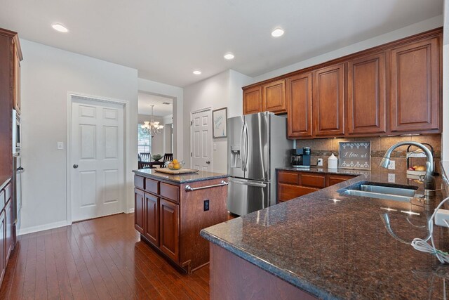 9905 Palmbrook Dr, Austin, TX 78717 - kitchen with appliances with stainless steel finishes, a sink, a chandelier, dark wood-type flooring, and brown cabinetry